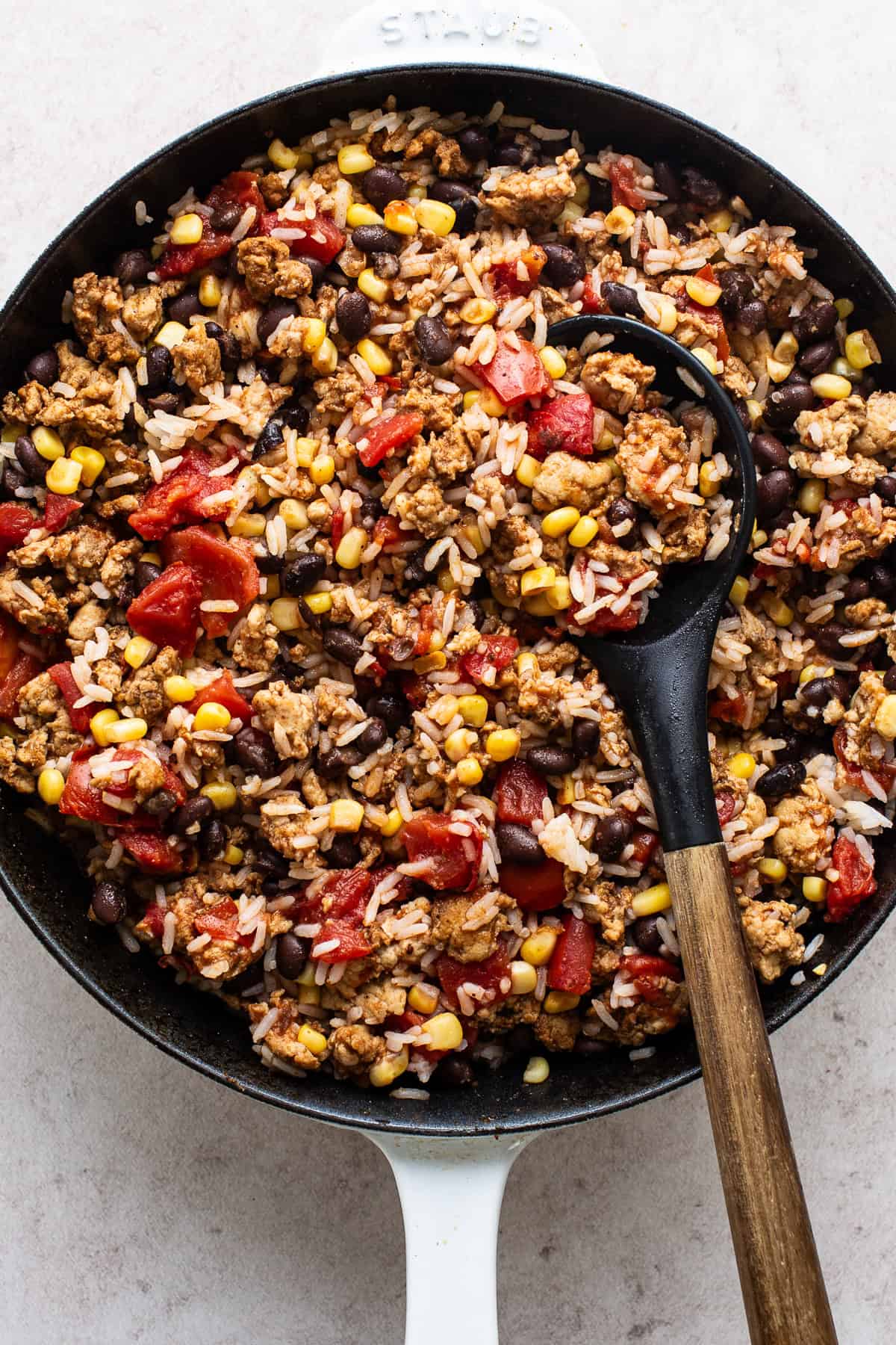 Mexican stuffed pepper filling cooked in a skillet with ground turkey, tomatoes, rice, black beans, and corn. 