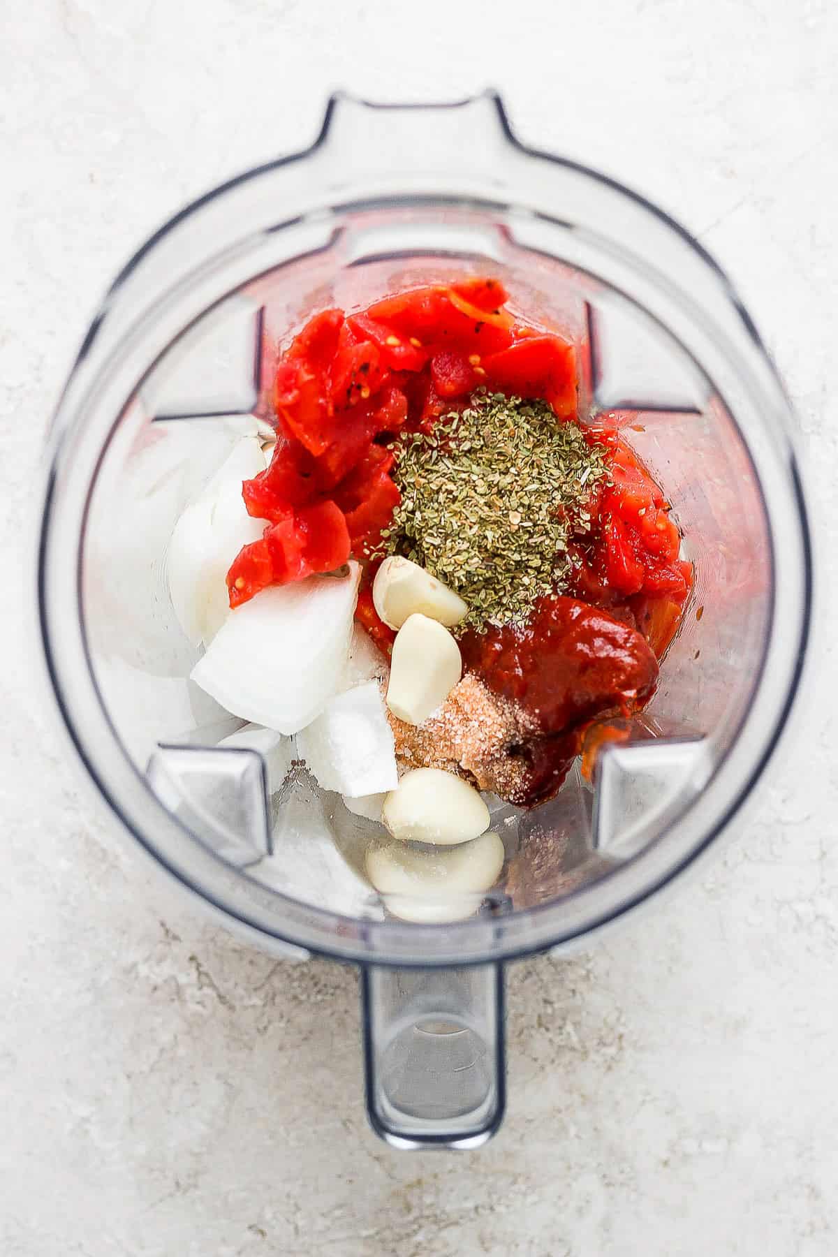 Tomatoes, chipotle peppers, onion, garlic, oregano, and salt all added into a blender