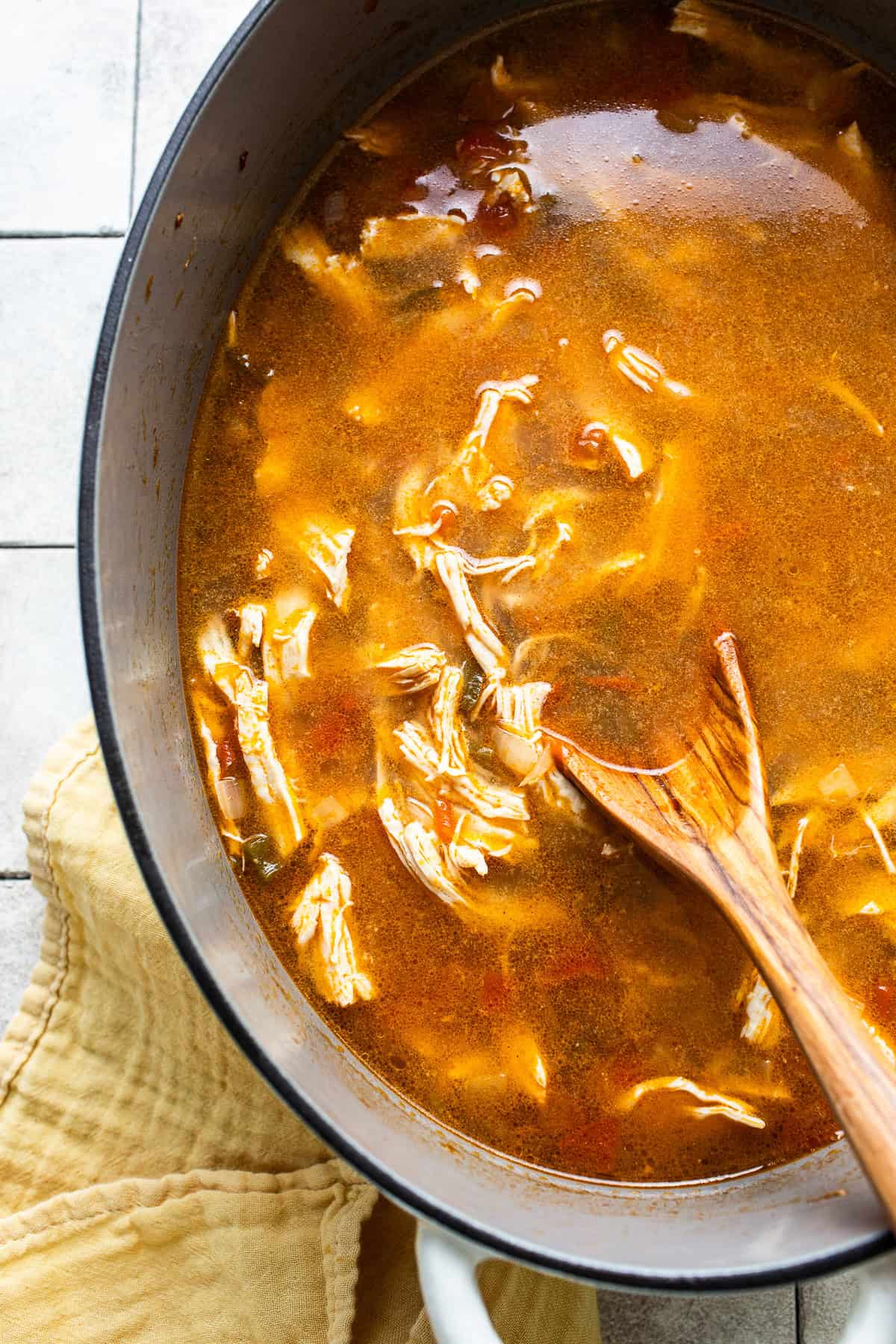 Sopa de lima with shredded chicken in a pot before serving.