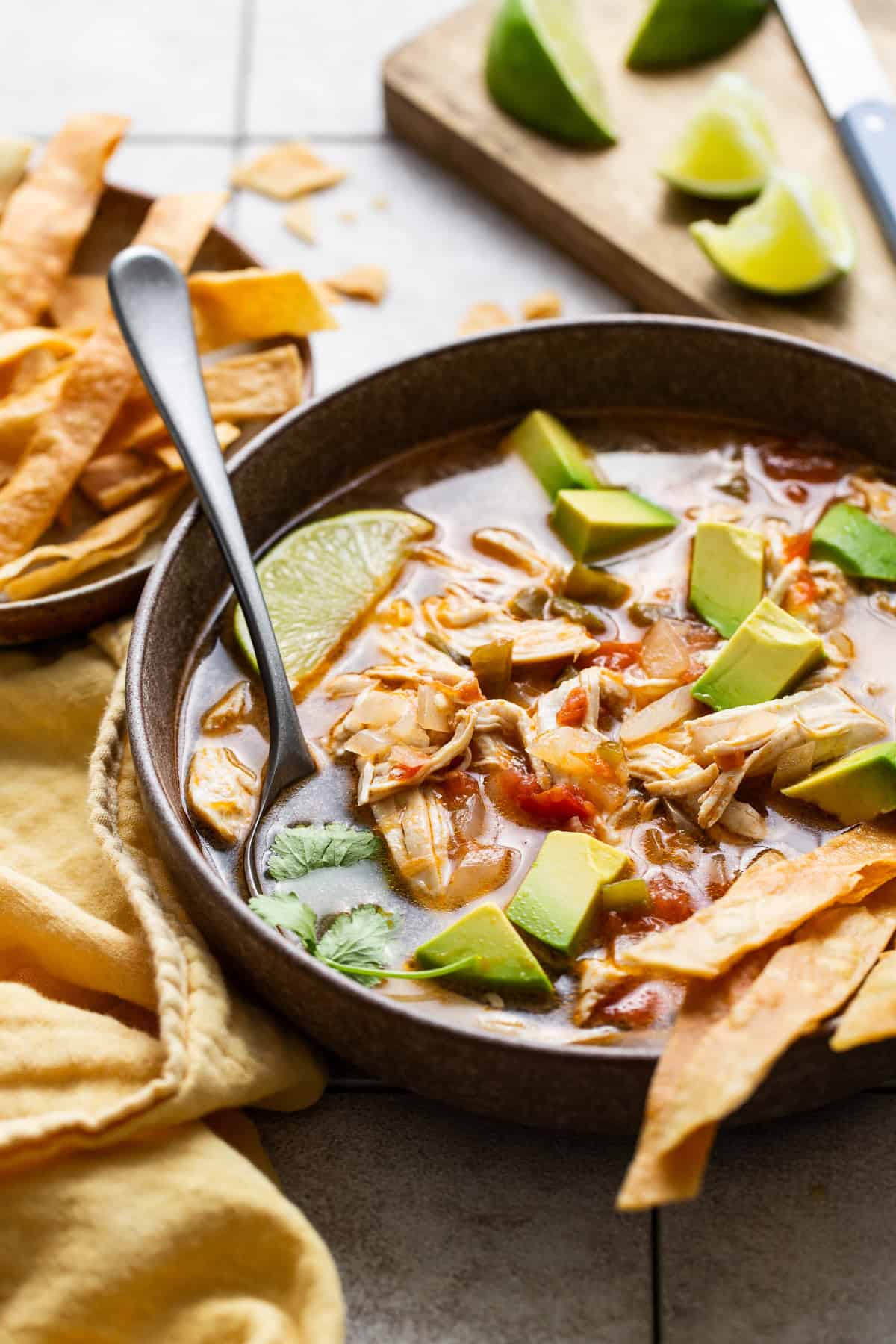 Sopa de lima served into bowls with tortillas trips, limes,, diced avocados 
 and cilantro. 