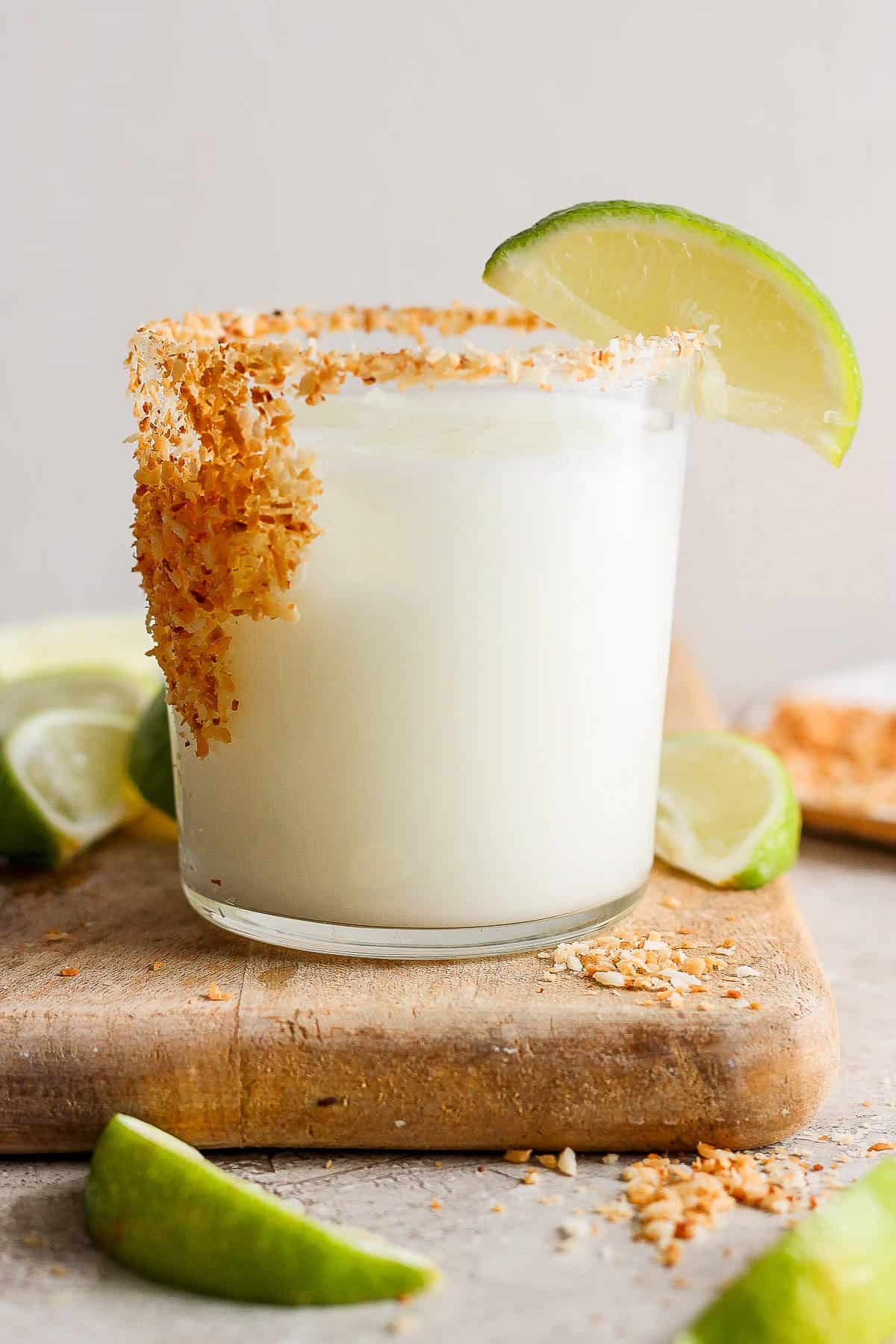 Coconut margarita served in a glass garnished with a lime
