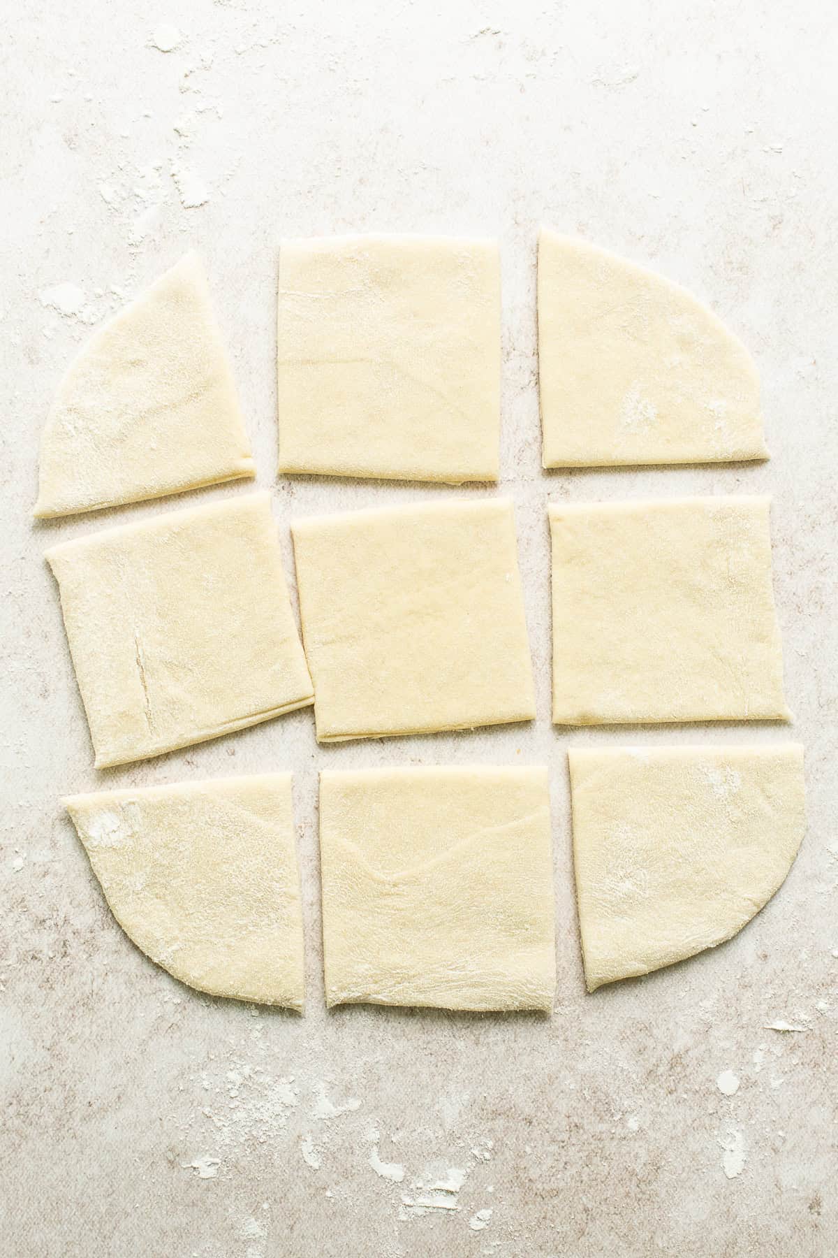 Sopapilla dough rolled out and cut into square shapes.