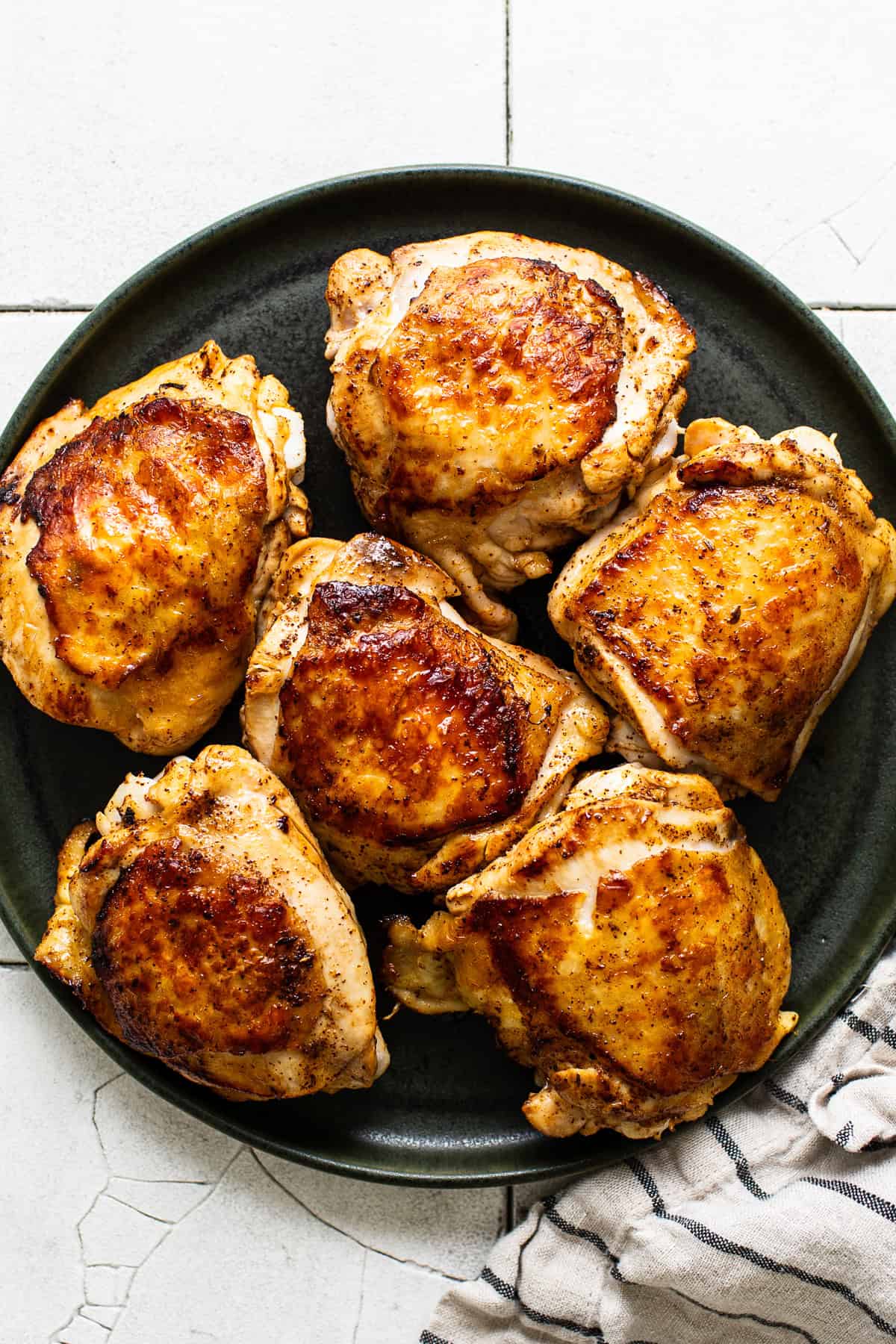 Browned chicken thighs on a platter