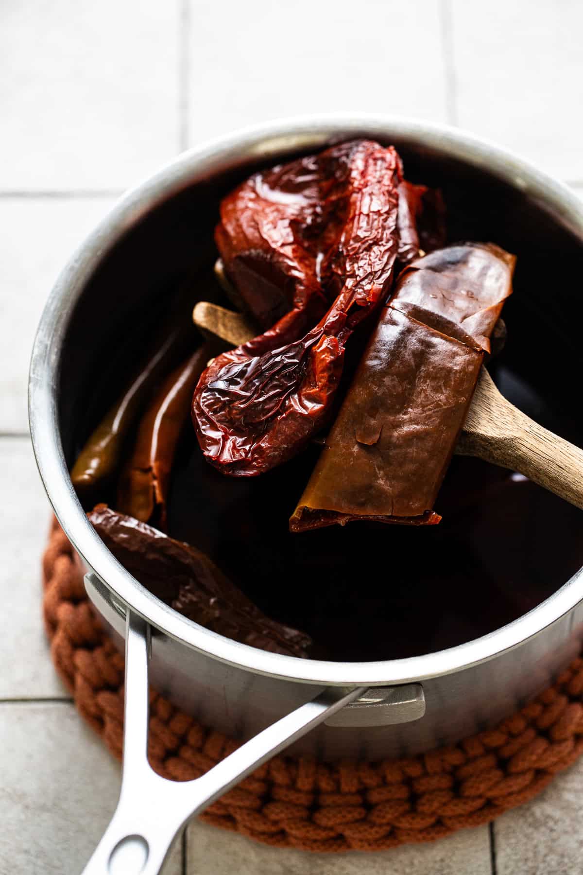 Rehydrating the dried chiles by soaking them in a pot of water