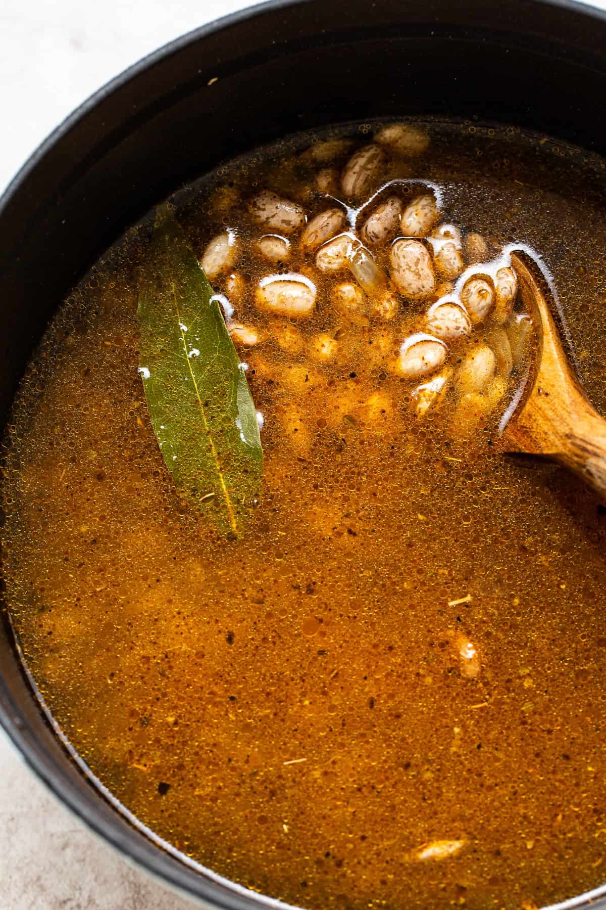 Beans, water, and aromatics added to a pot.