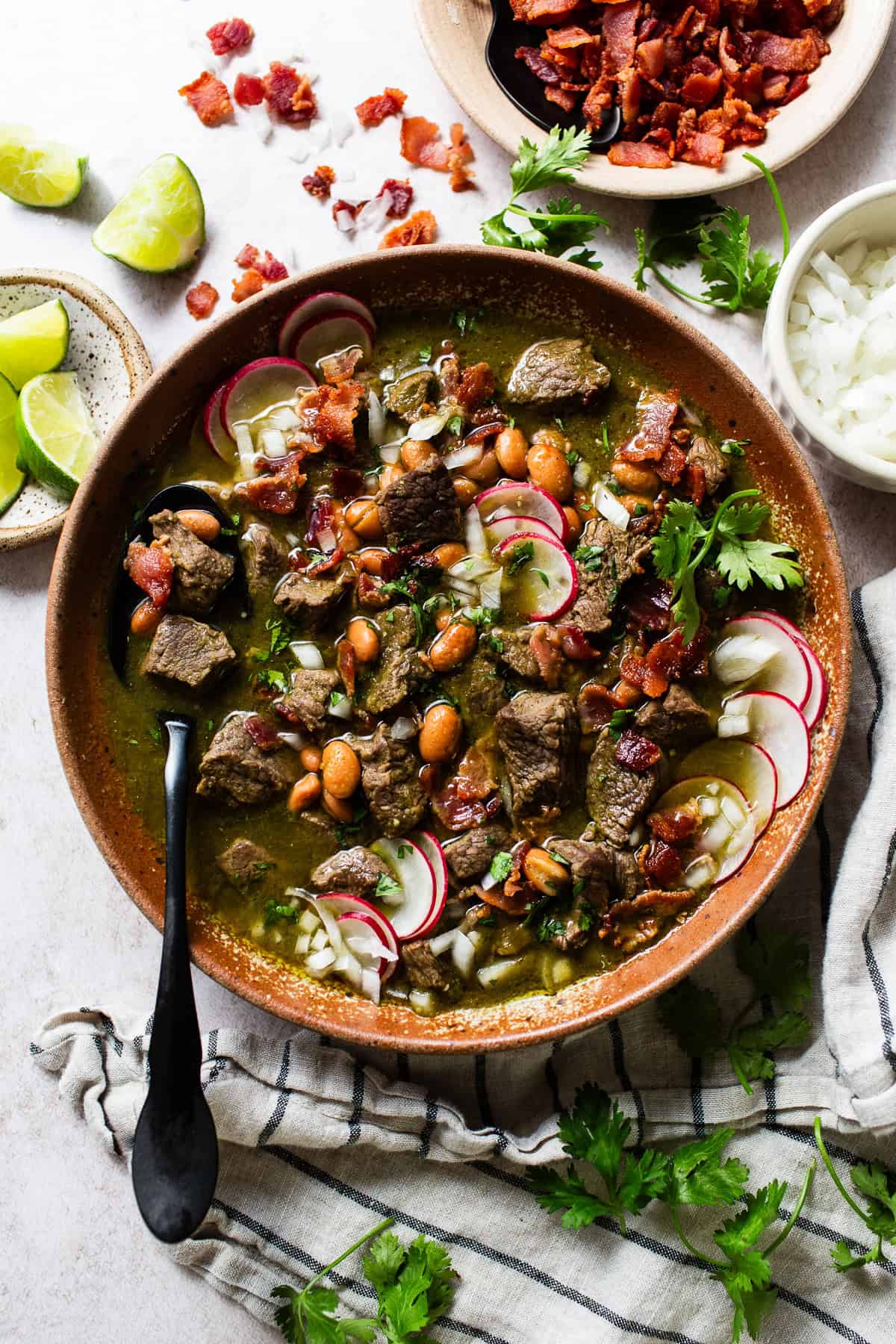 Carne en su jugo topped with bacon, onions, radish, and other toppings