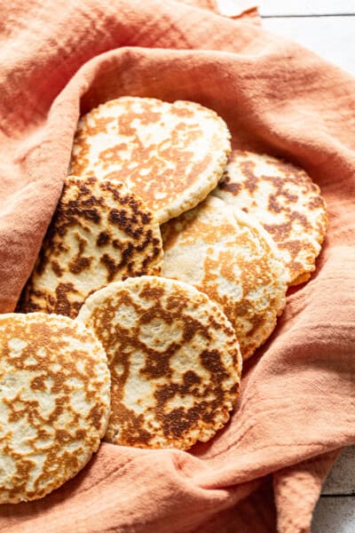 Gorditas de azucar (Mexican griddle cakes) wrapped in a clean kitchen towel ready to eat.