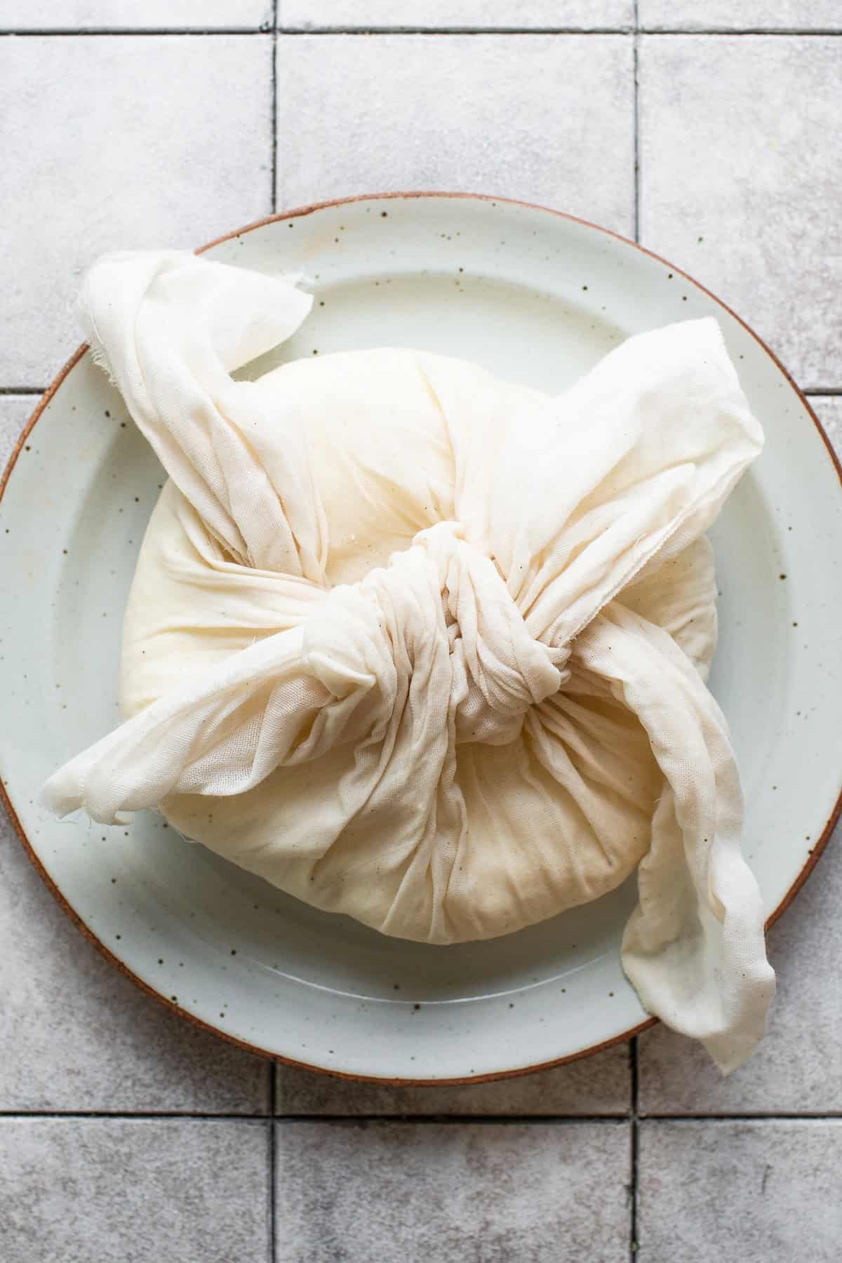 Tied cloth around queso fresco.