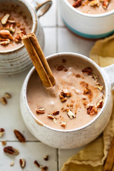 Atole de nuez in a mug with a cinnamon stick.
