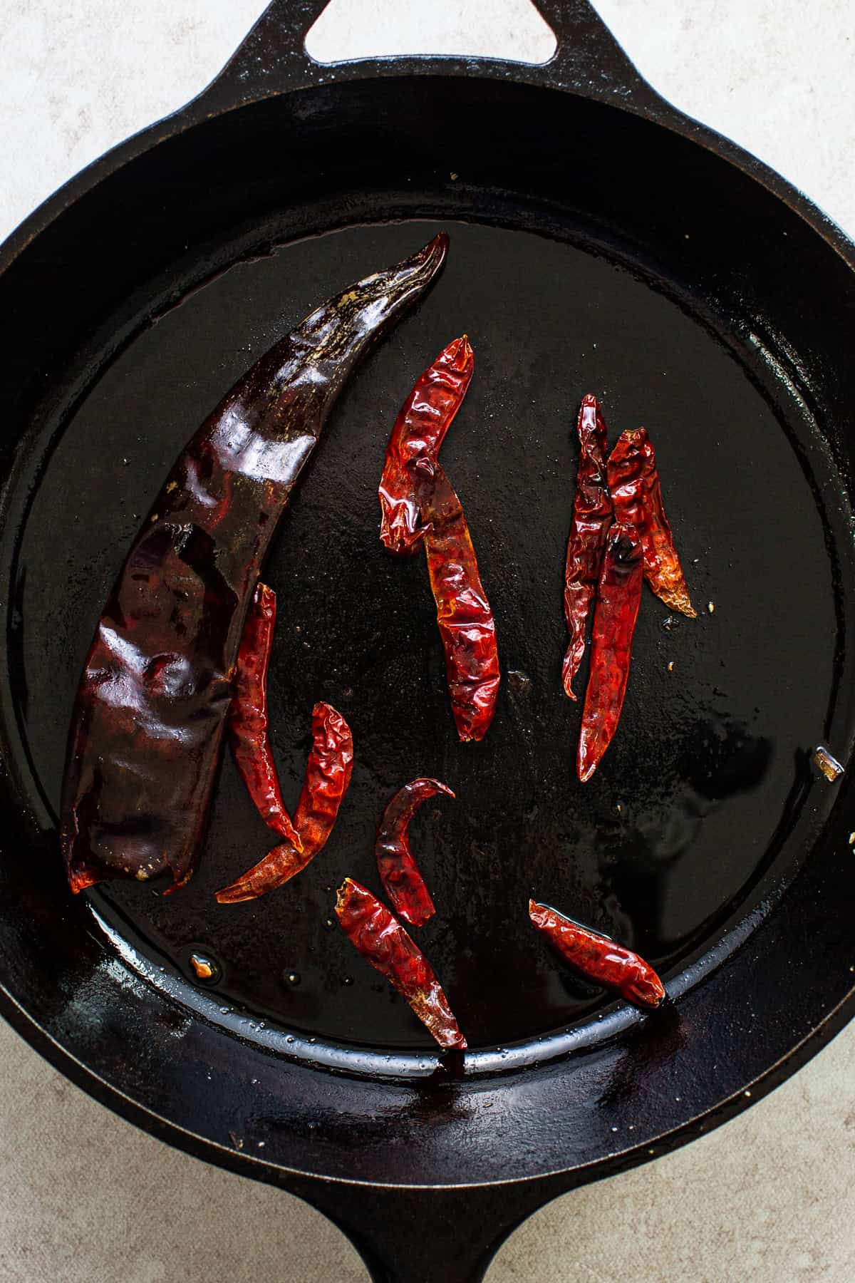 Árbol and guajillo chiles toasting in a dry skillet.