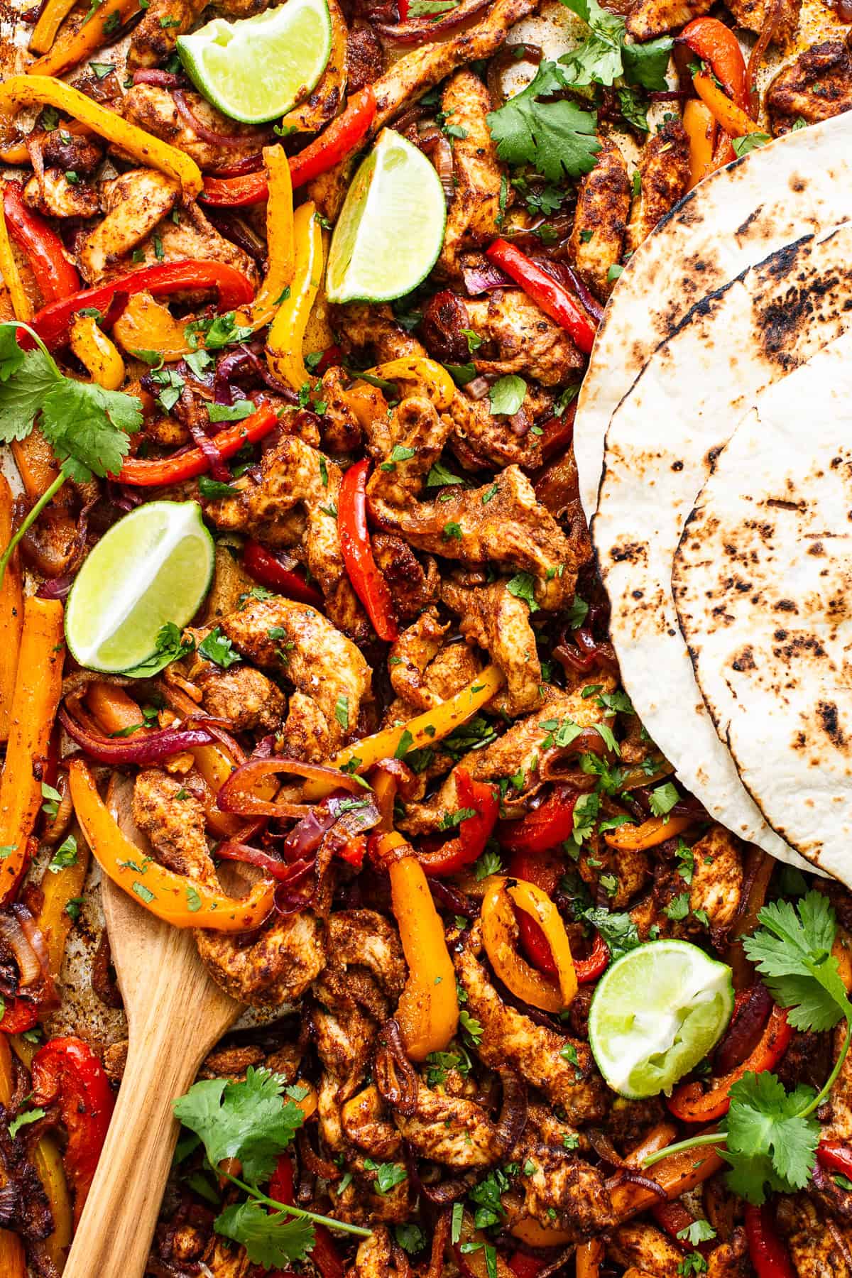 Sheet pan chicken fajitas with tortillas ready to eat.