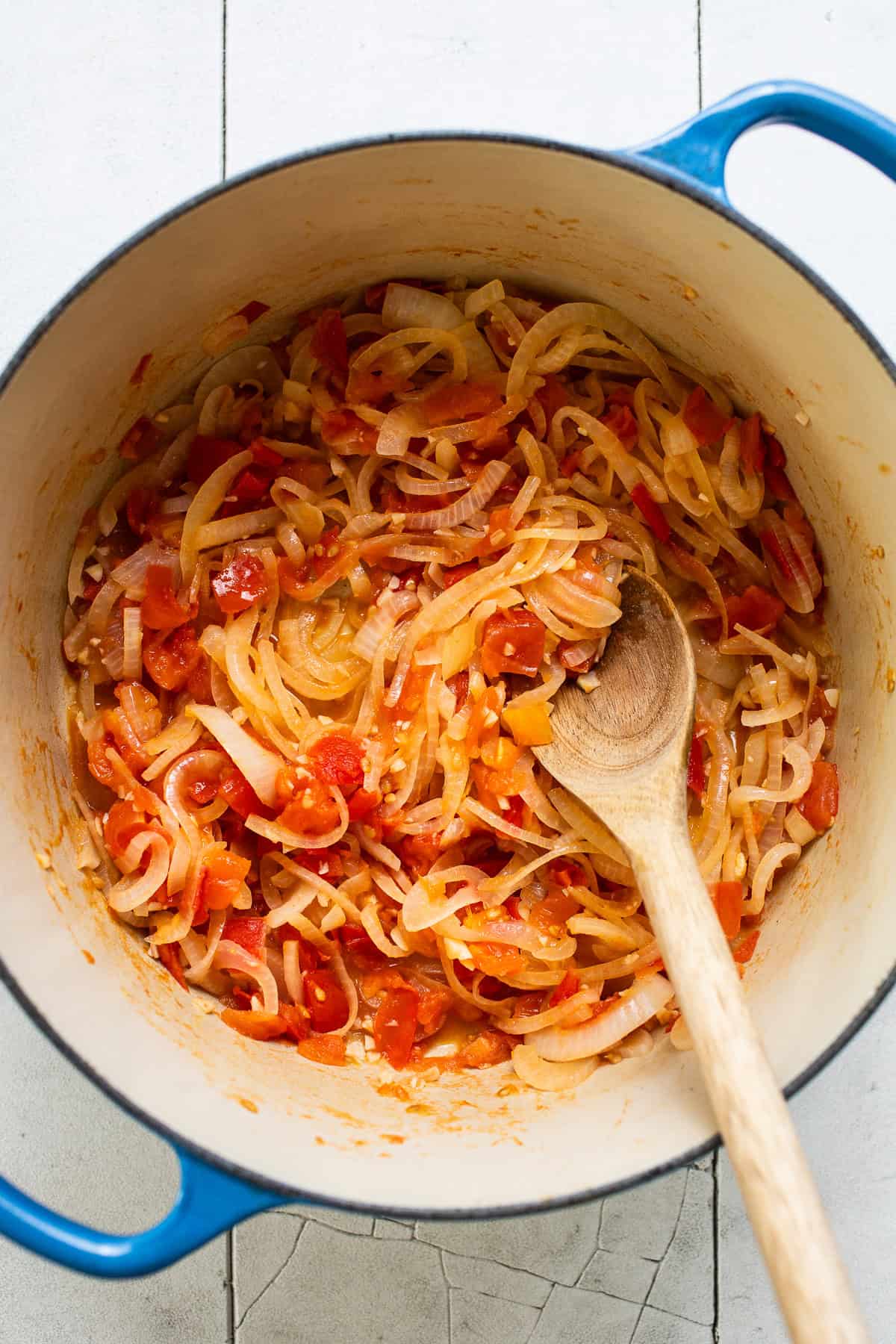 Sauteed onions, tomatoes, and garlic in a pot.