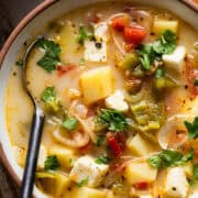 Caldo de queso in a bowl garnished with fresh cilantro.