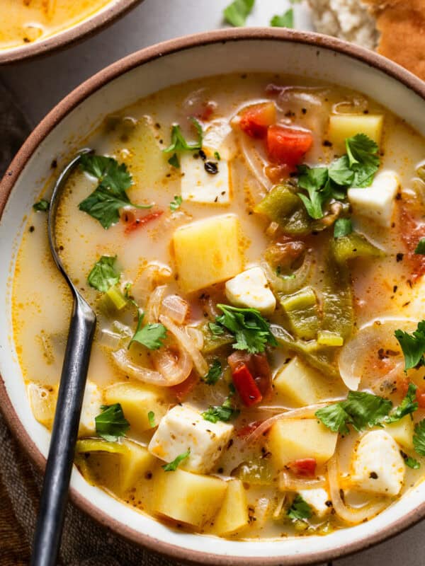 Caldo de queso in a bowl garnished with fresh cilantro.