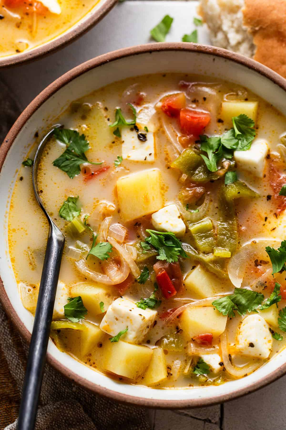 Caldo de queso in a bowl garnished with fresh cilantro.