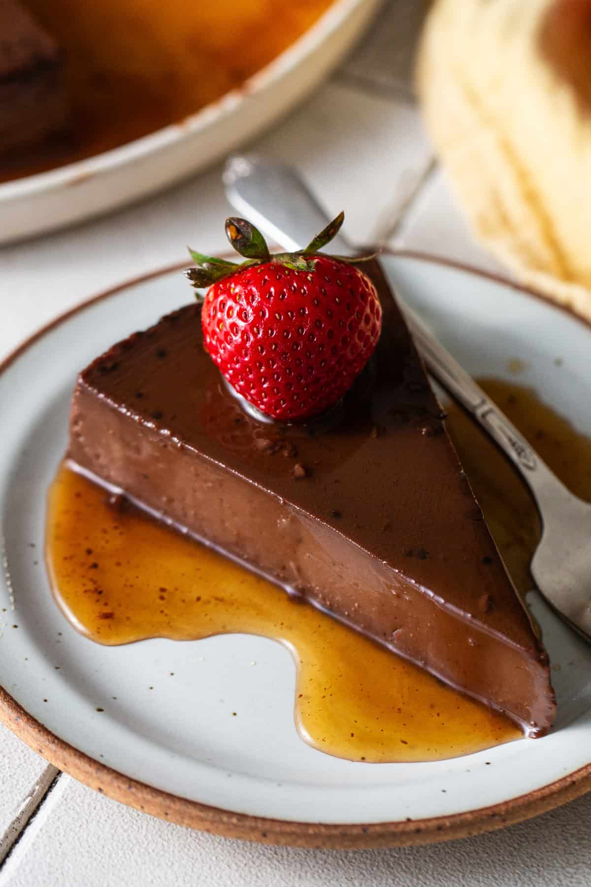 A slice of chocolate flan on a plate.