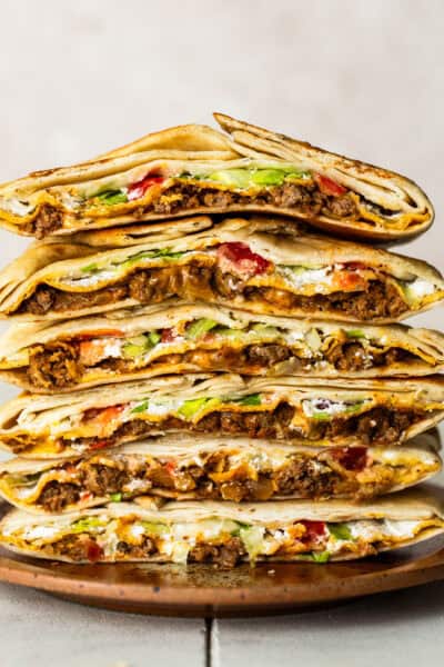 Cross sections of many crunchwrap supremes stacked on top of one another.