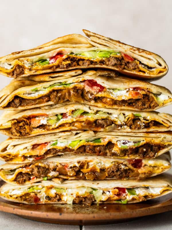 Cross sections of many crunchwrap supremes stacked on top of one another.