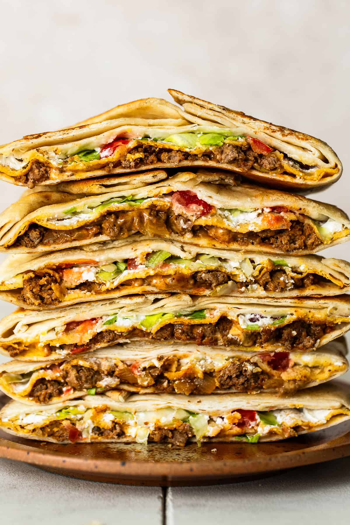 Cross sections of many crunchwrap supremes stacked on top of one another.