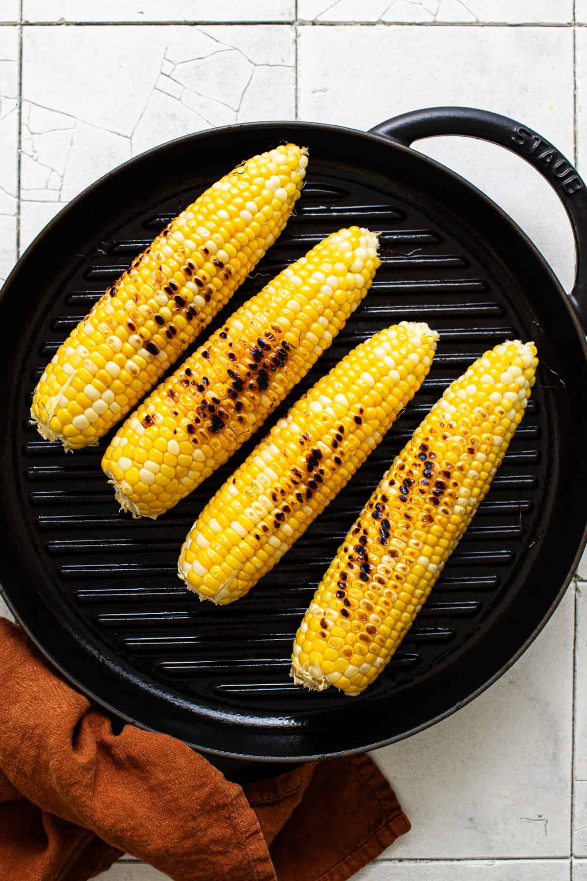 Corn on the cob grilled on a grill pan.