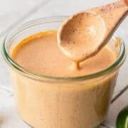 Chipotle ranch in a jar with a wooden spoon.