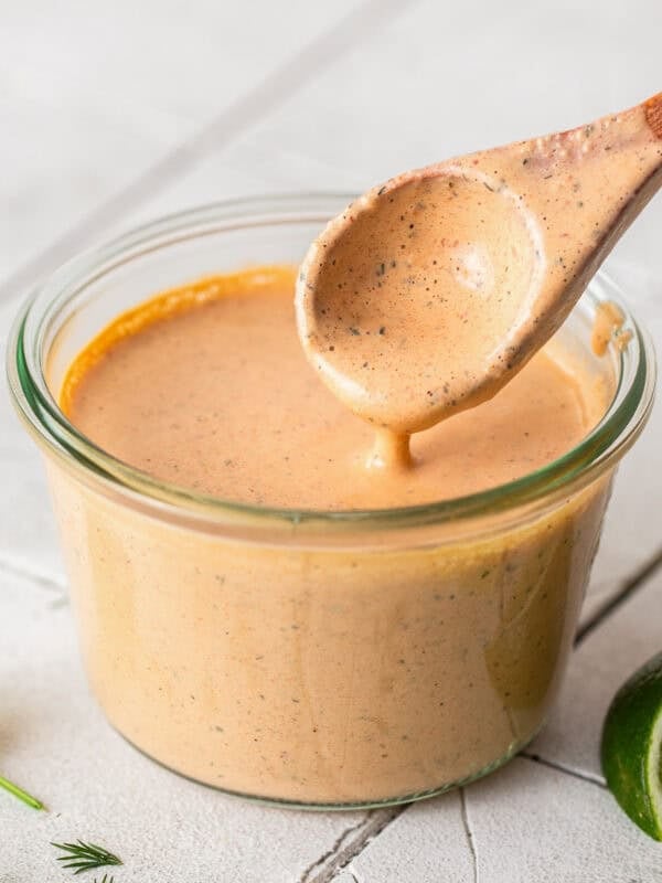 Chipotle ranch in a jar with a wooden spoon.