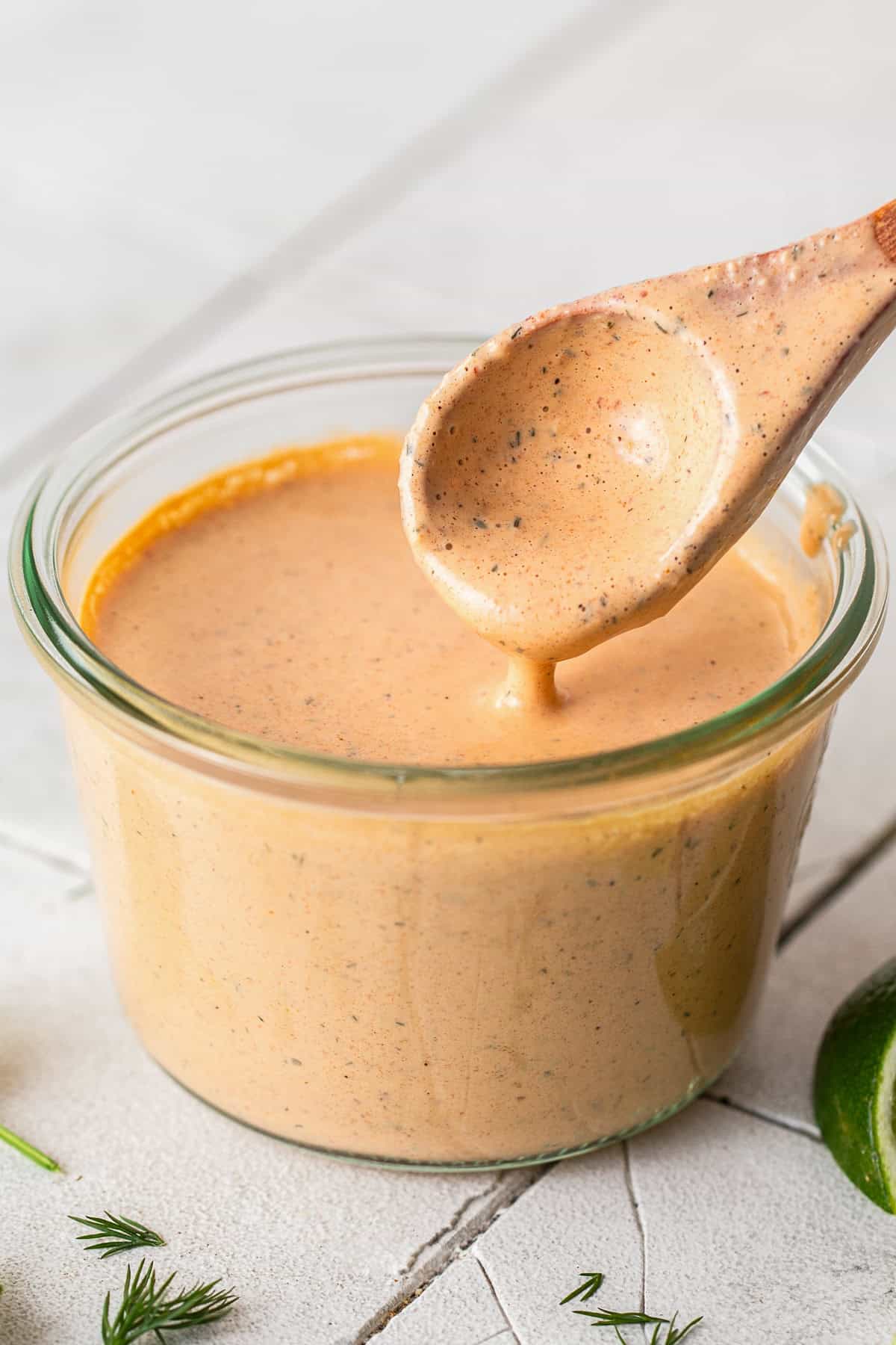 Chipotle ranch in a jar with a wooden spoon.