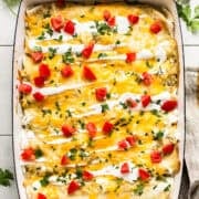 Cream cheese chicken enchiladas in a baking dish.