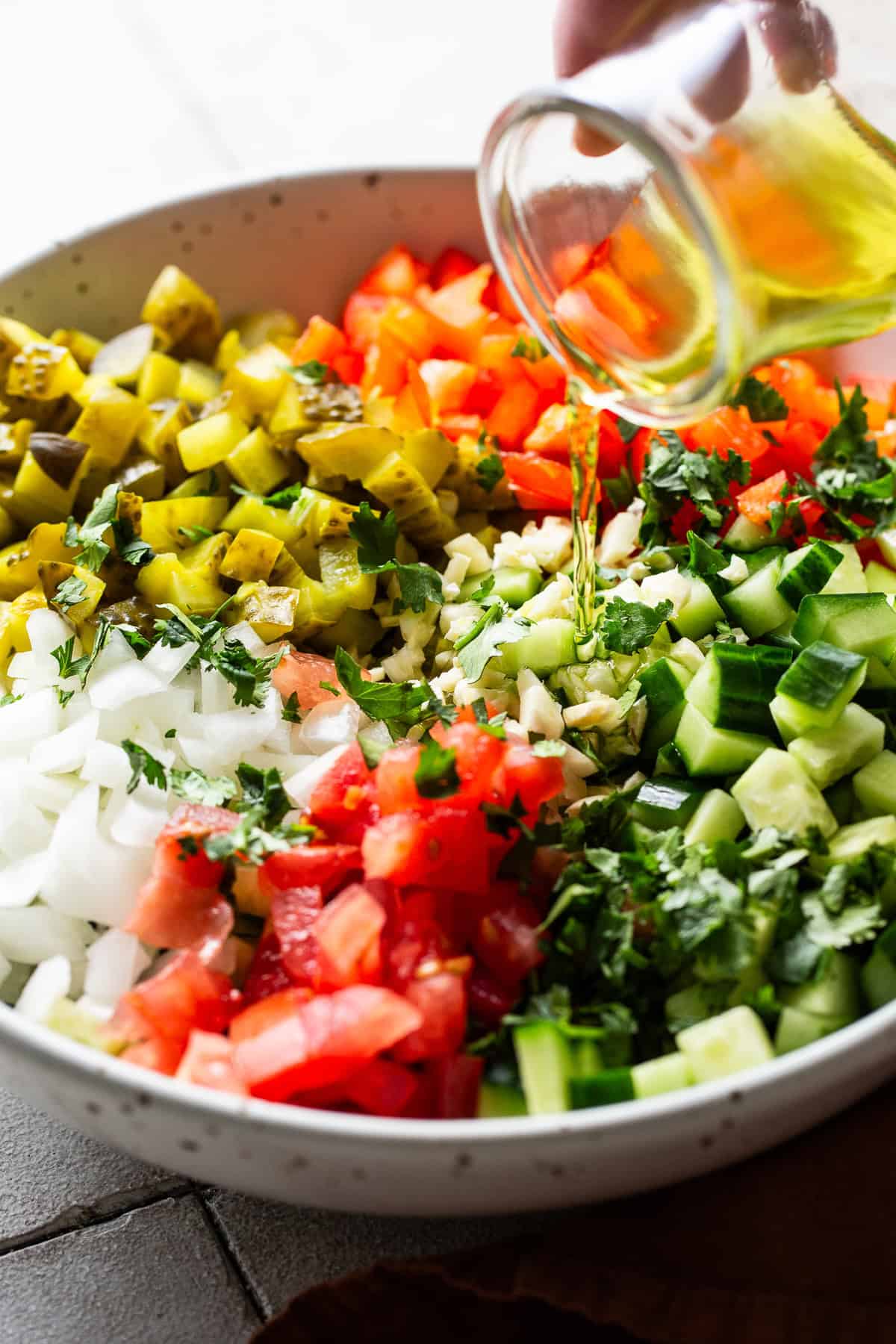 Pickle brine being poured into a bowl of ingredients for pickle de gallo.
