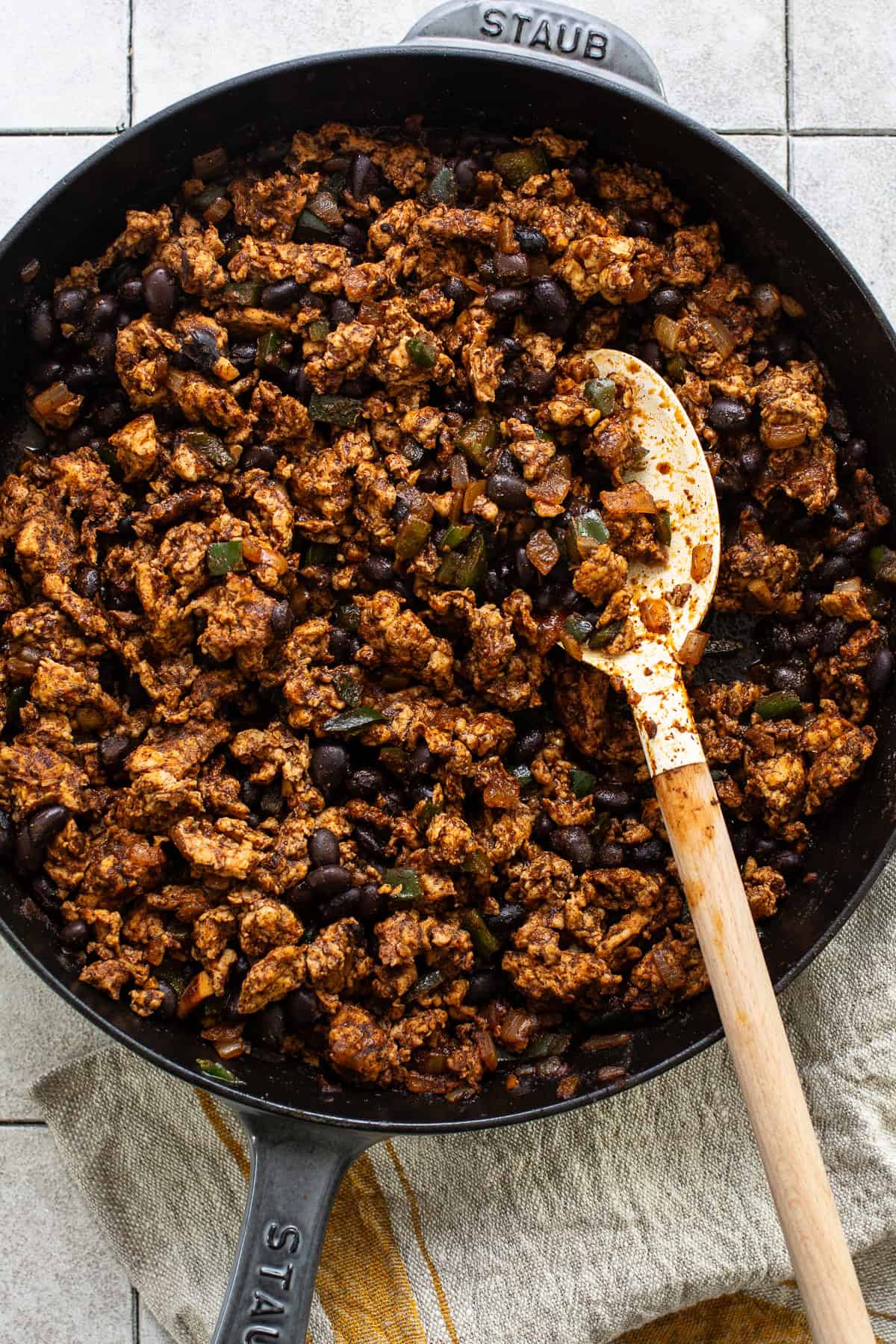 Cooked ground chicken and black beans in a skillet.