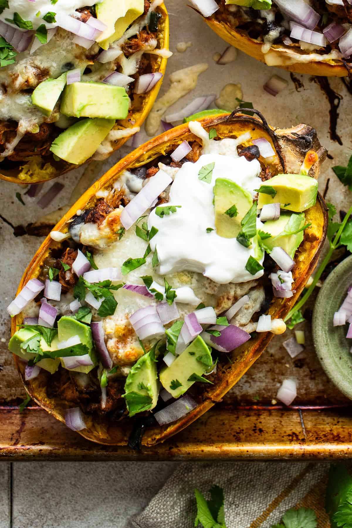 Spaghetti squash boats served with a dollop of sour cream, diced avocado, and cilantro.