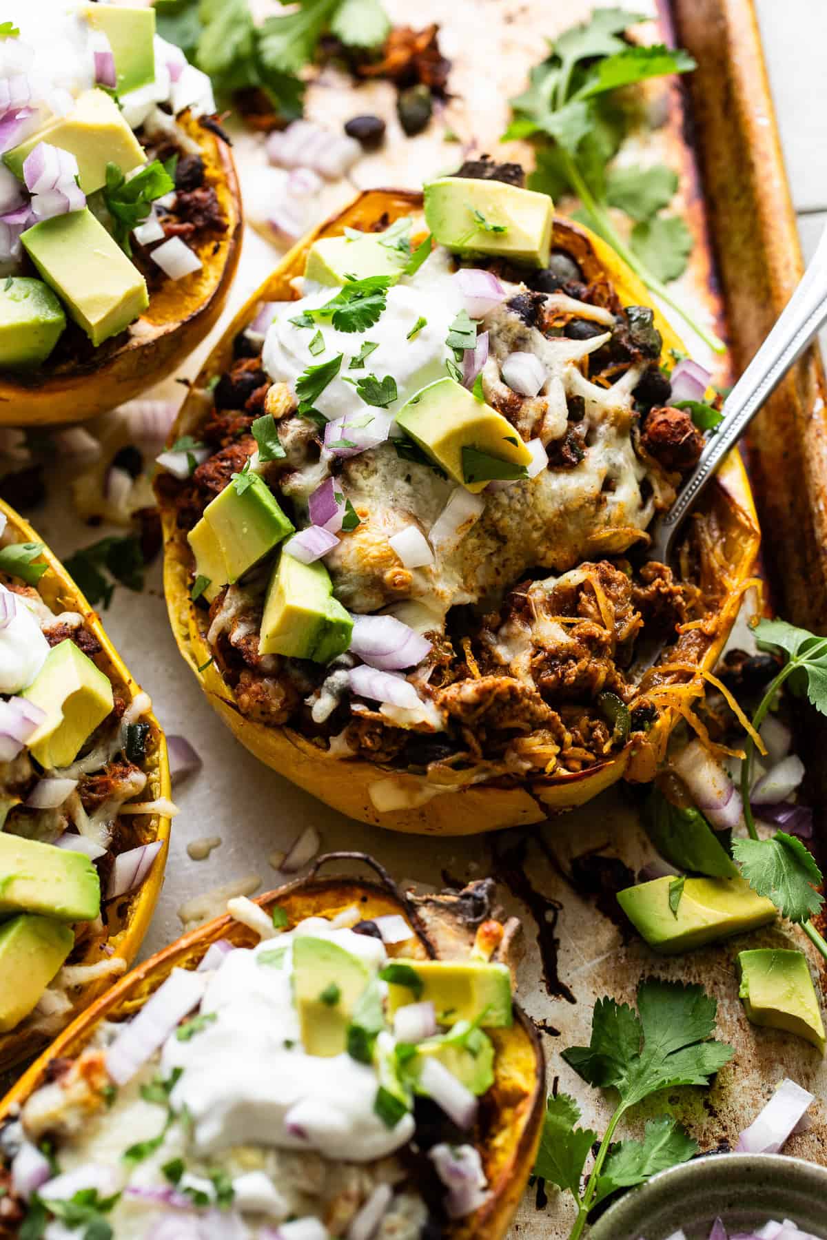 Stuffed spaghetti squash with a fork being eaten.