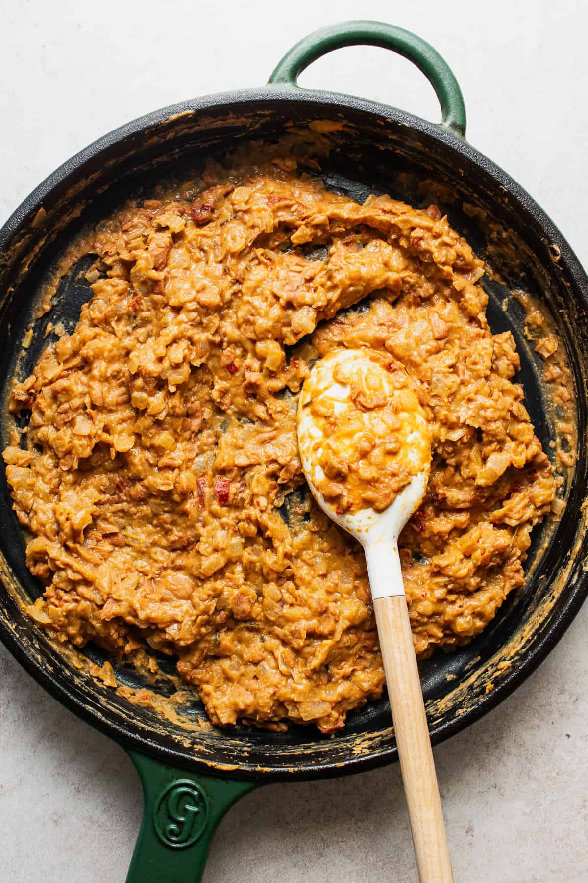 The mashed bean filling for bean and cheese taquitos in a skillet.