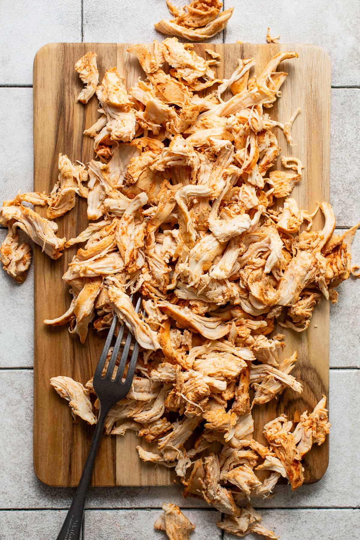 Shredded chicken on a cutting board.