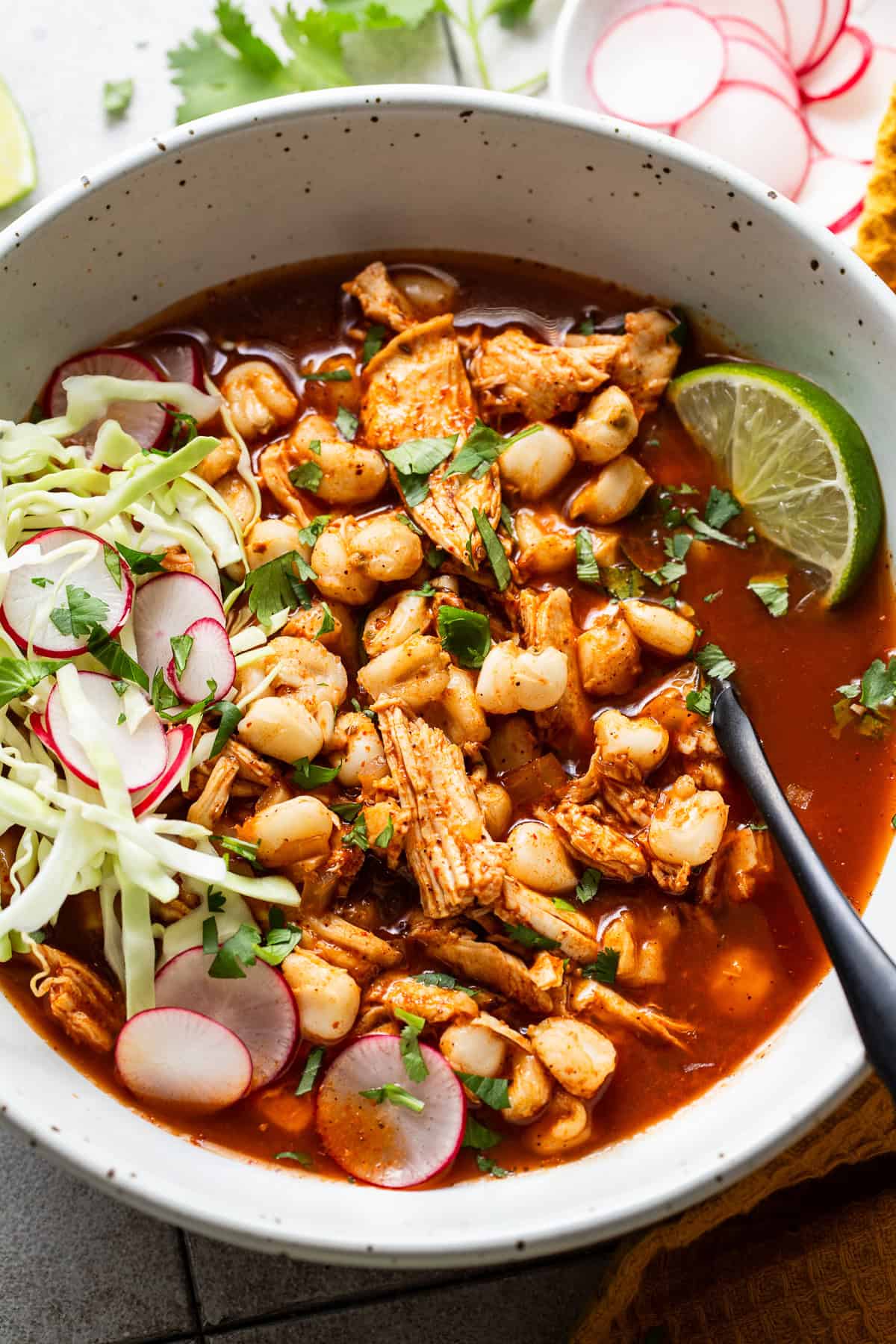 A bowl of chicken pozole ready to eat.