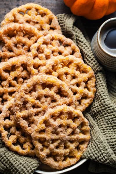 Crispy pumpkin buñuelos de viento covered with cinnamon sugar.