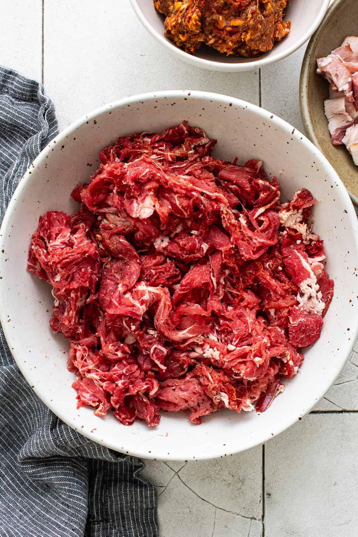 Thinly shaved steak in a bowl for tacos de alambre.