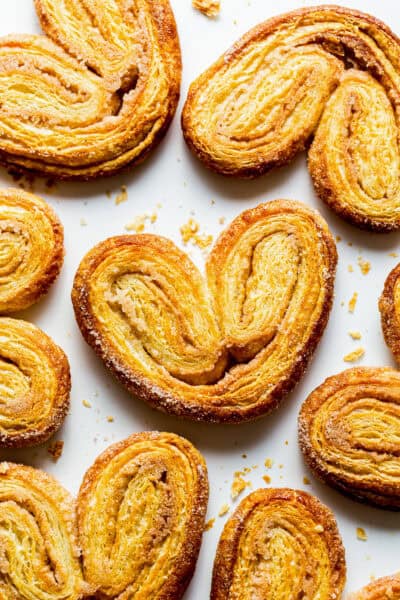 Crispy orejas pan dulce on a baking sheet with lots of cinnamon sugar.