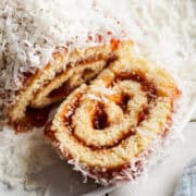 A niño envuelto roll on a serving plate with a slice taken out.