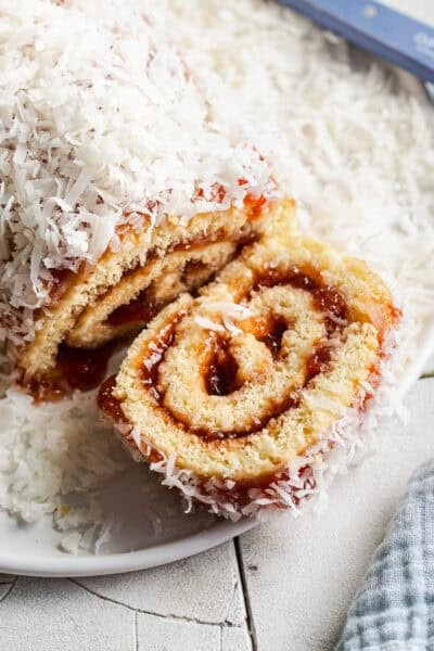 A niño envuelto roll on a serving plate with a slice taken out.