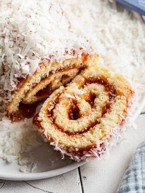 A niño envuelto roll on a serving plate with a slice taken out.