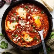 Huevos ahogados in a cast iron skillet.