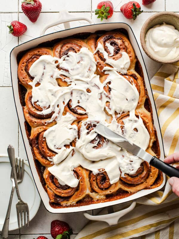 Tres leches cinnamon rolls with cream cheese icing in a tray ready to serve.