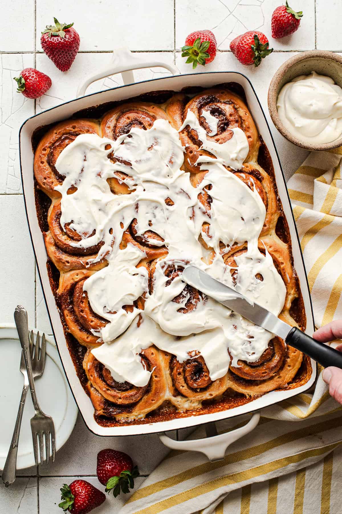 Tres leches cinnamon rolls with cream cheese icing in a tray ready to serve.