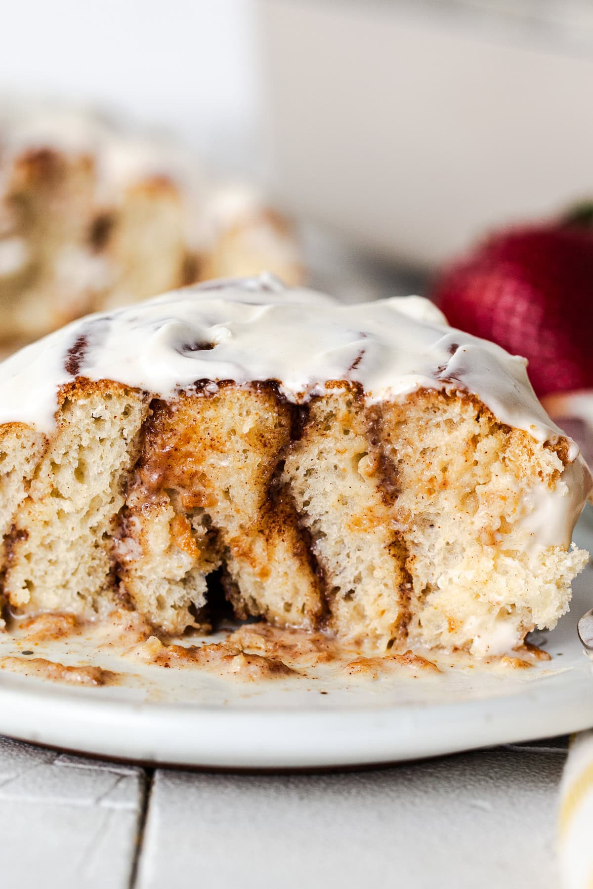 A close up of a tres leches cinnamon roll cross section on a plate.
