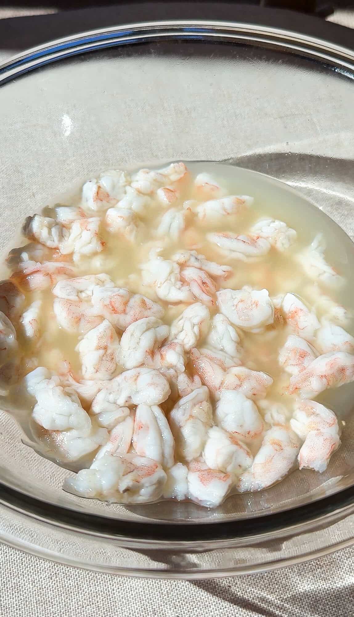 Shrimp "cooking" or marinating in lemon and lime juice to make Mexican ceviche.
