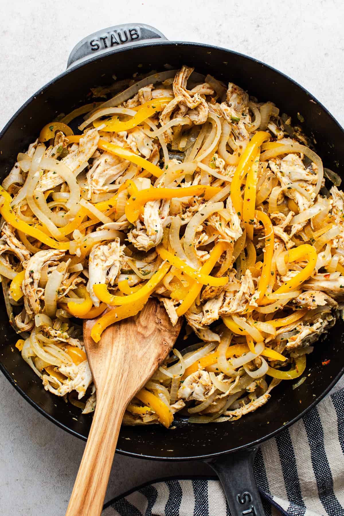 Shredded chicken, bell pepper, and onion filling in a skillet for rotisserie chicken tacos