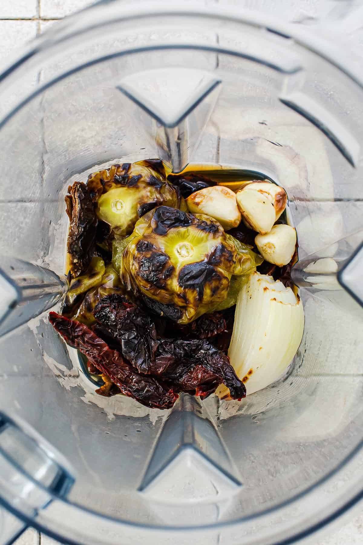 All the roasted and charred ingredients for the salsa in a blender before being blended.
