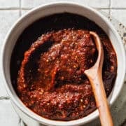 A bowl of salsa morita woth a wooden spoon ready to eat.