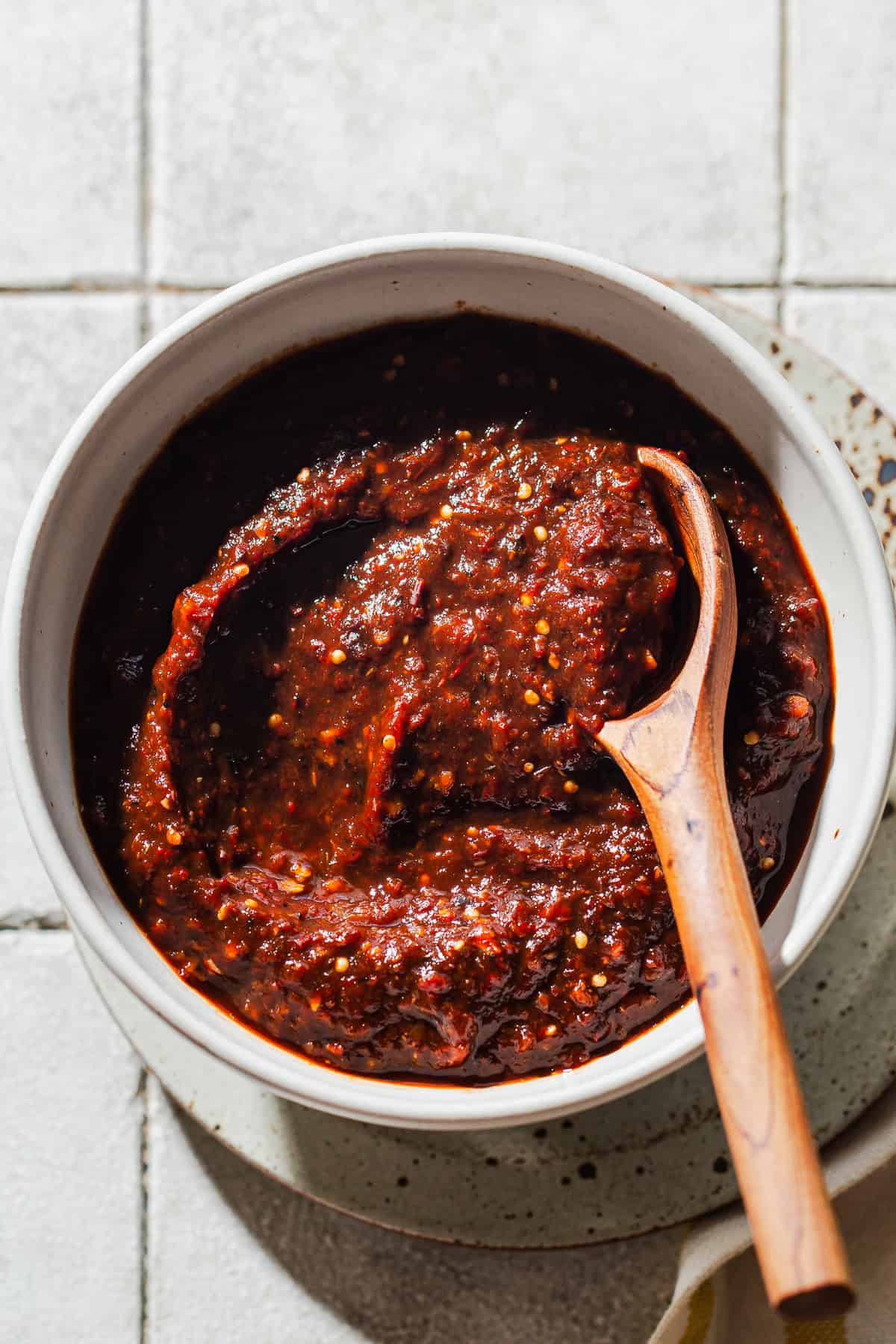 A bowl of salsa morita woth a wooden spoon ready to eat.